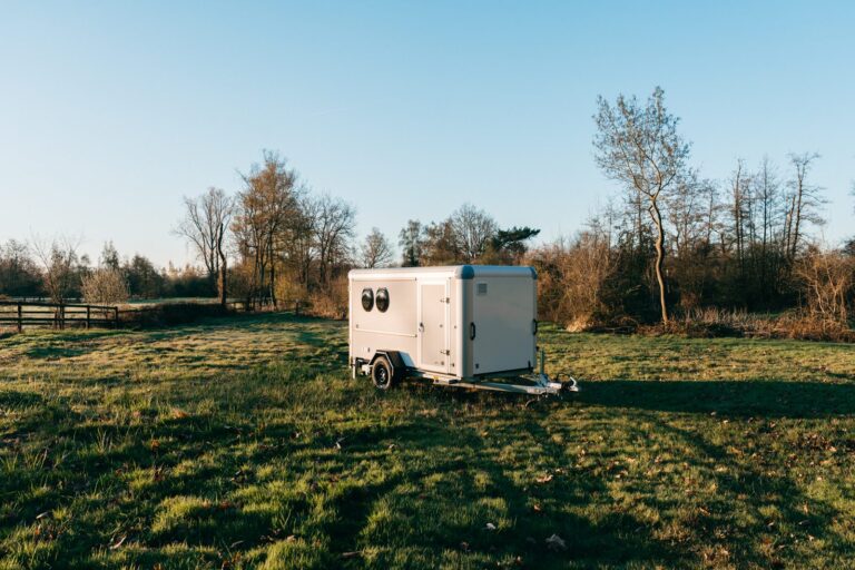 TraileeH glampingtrailer in een weide bij zonsopgang